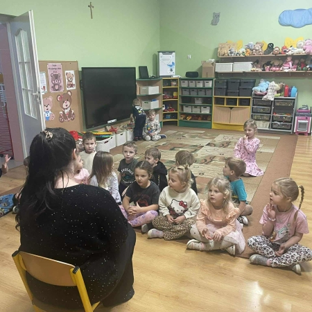 Fotografia kolorowa. Bibliotekarka robi dzieciom misiowy quiz. 